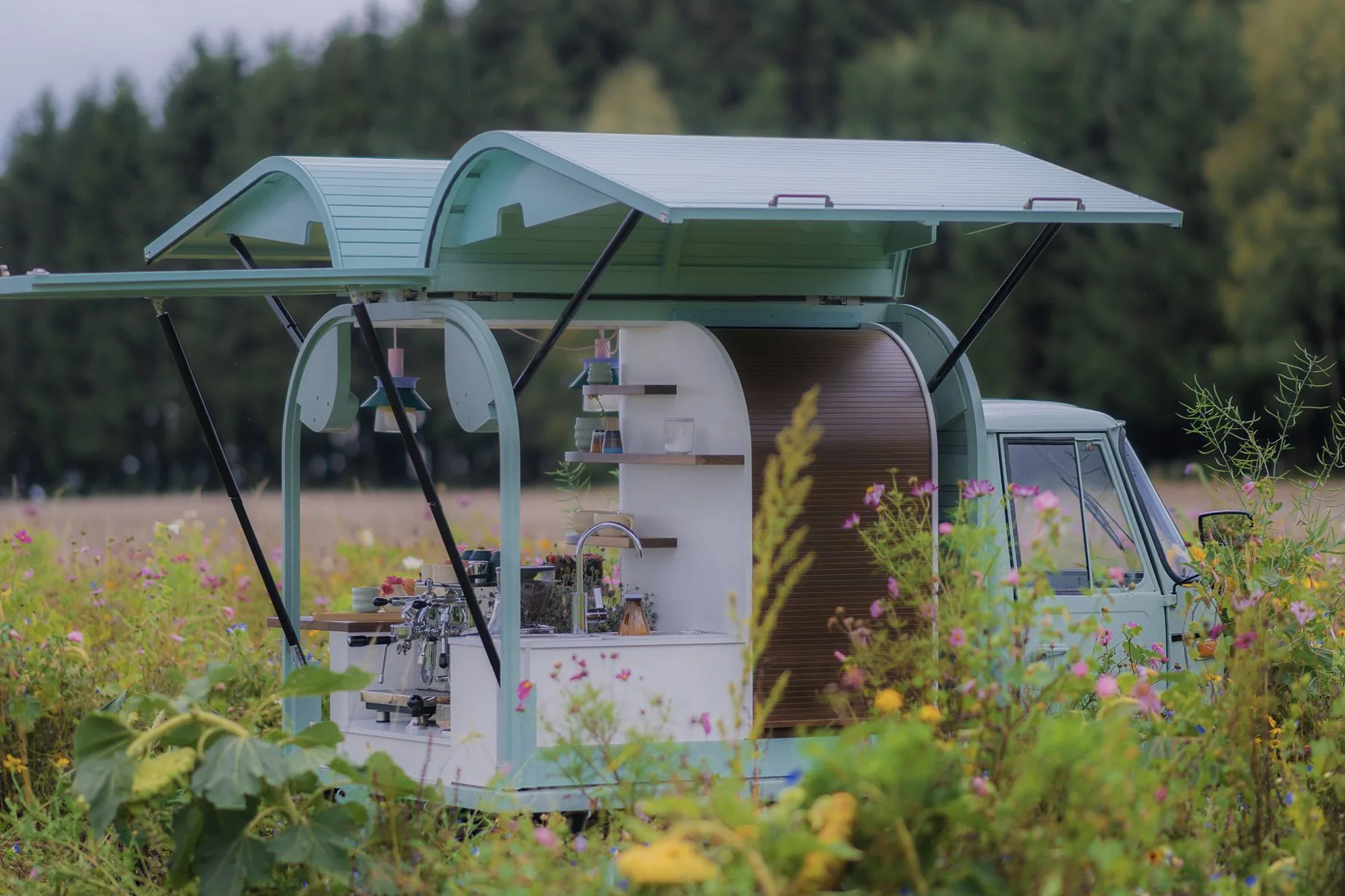 Salbei-grüne Pocissimo-Ape in einer Wildblumenwiese mit aufgeklappter Theke